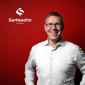 Portrait vor rotem Hintergrund mit Logo: Gründer und Geschäftsführer Mike Olaf Sartissohn von der Sartissohn Software GmbH